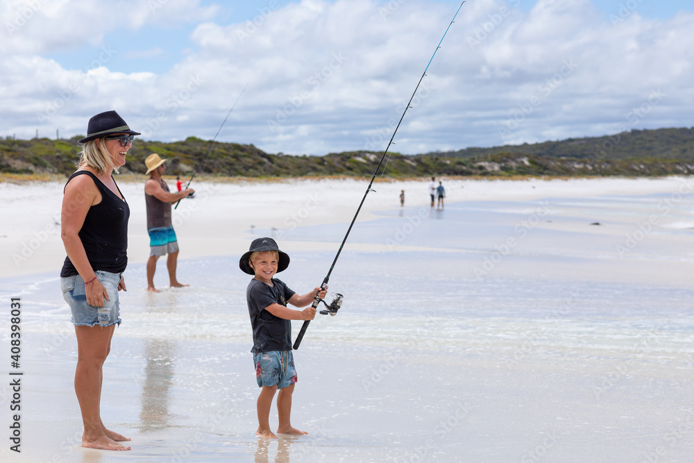 family fishing on white sand beach